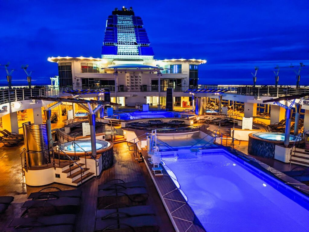 The Cruise-Ferries With En-Suite Cabins, Restaurants and Space to Unwind Cruise ferry pool deck lit at twilight