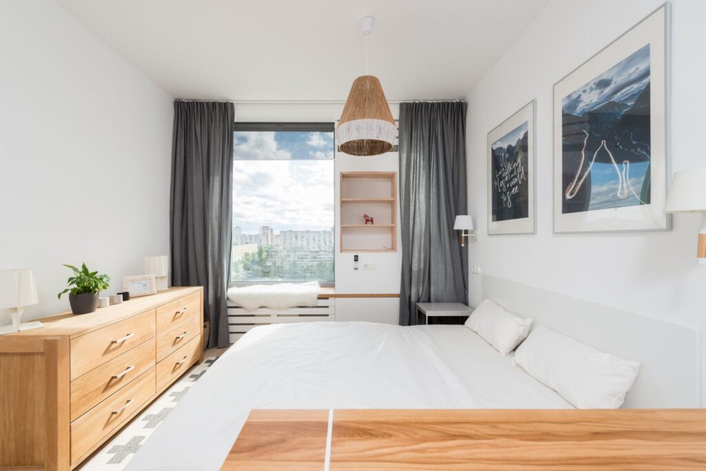 The Hotels in the Middle of Gothenburg and Malmö Light hotel room with white bedding, an oak chest and a city view through the window