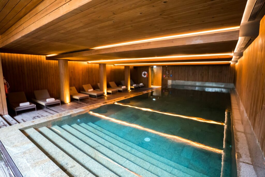 Pool Hotels in Sweden, From Stockholm to Luleå Indoor hotel pool lined with timber, with loungers along one side