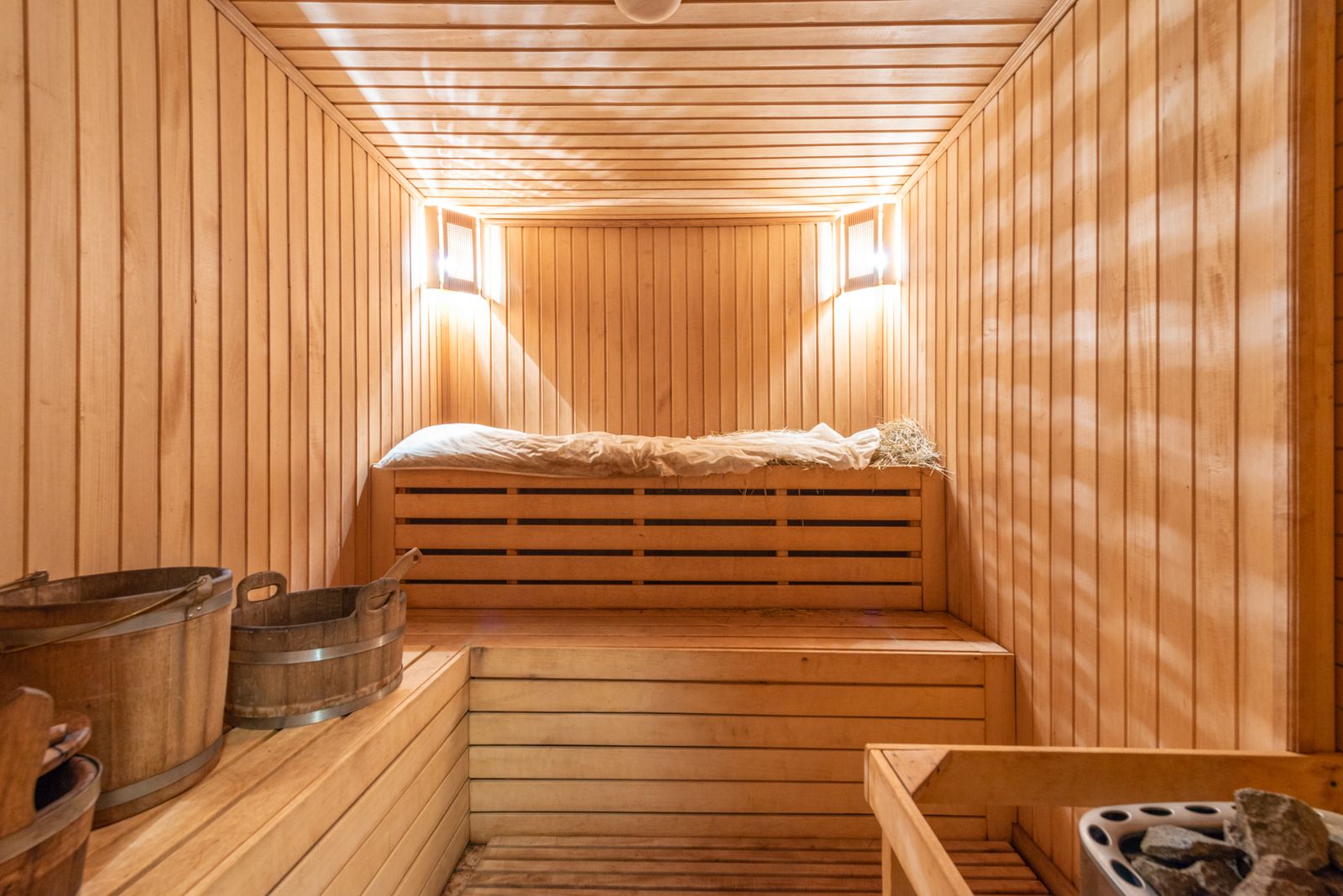 Wood-lined hotel sauna with benches and water buckets